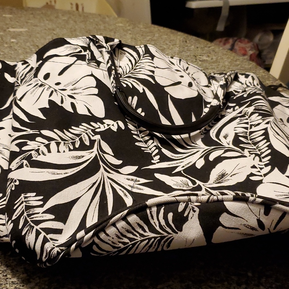 Large black and white tropical print tote bag with attached wallet.